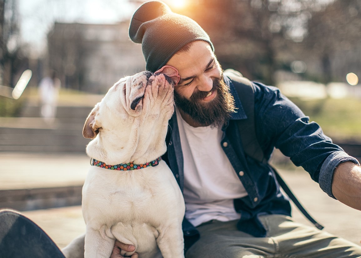 A dog licking its owner's smiling face