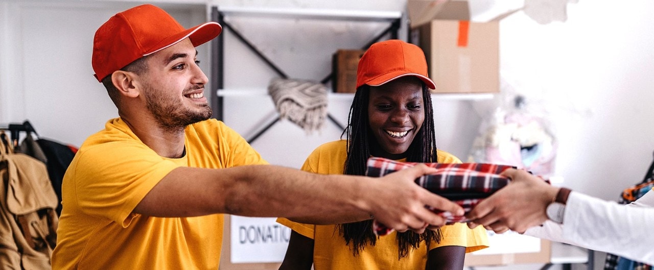 Multiethnic volunteers handing supplies to recipient