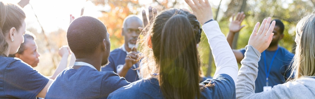 Group of volunteers raising their hands