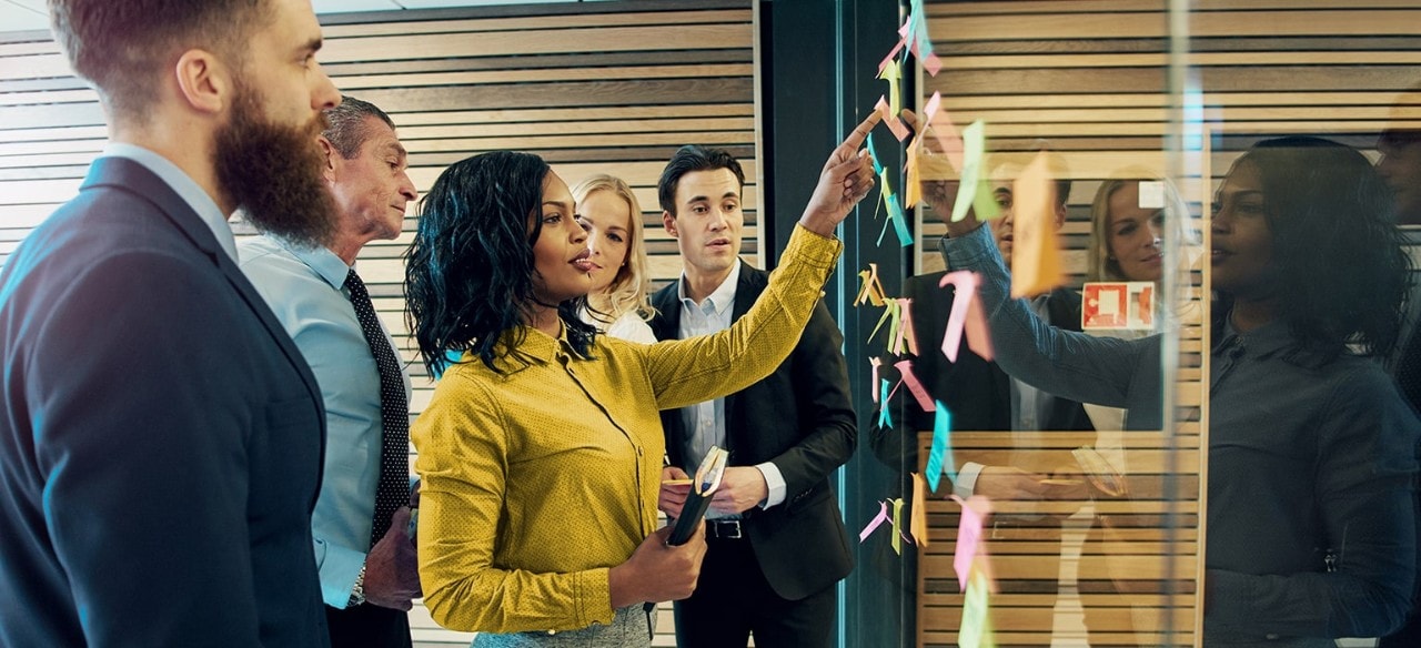 African-American consultant leading brainstorm session with team of business people