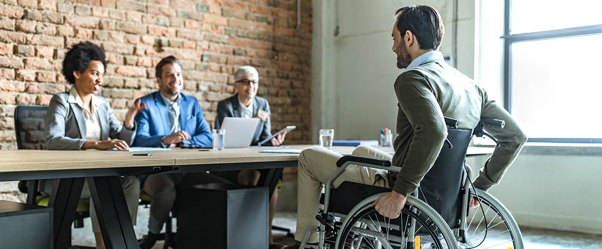 Man in wheelchair interviewing with a group of diverse business people