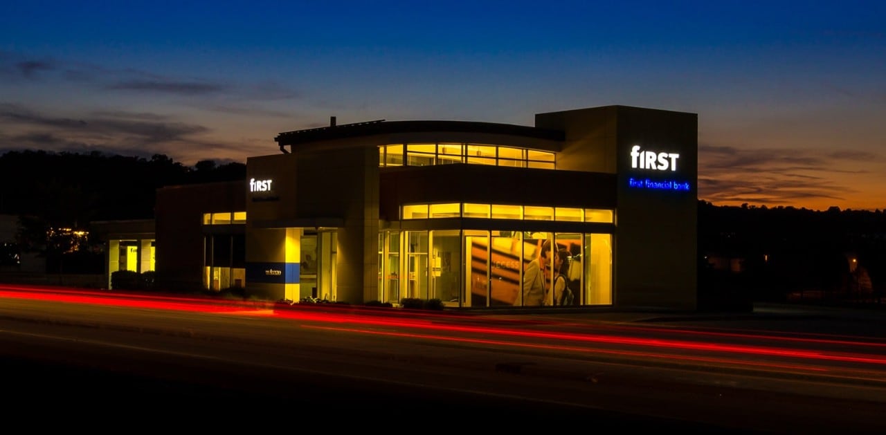 First Financial banking center at sunset with streak of car tail lights