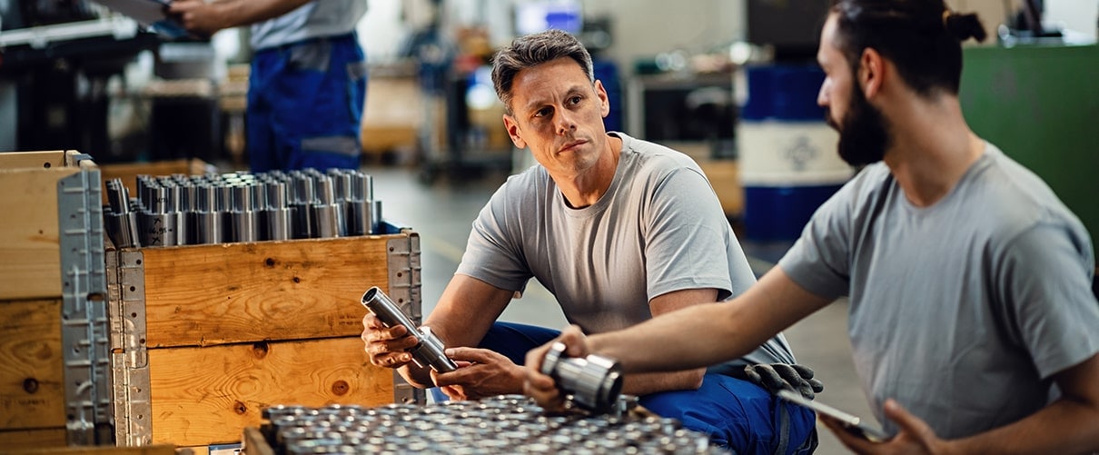 Two men stocking machine parts in a warehouse