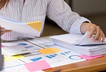 Female business owner reviewing stack of organized financial files