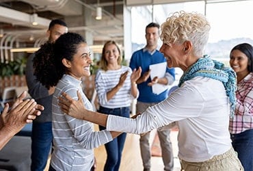 Employees clapping and being recognized by manager
