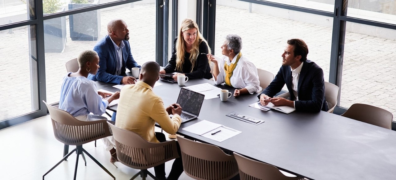 Group of colleagues conversing in a conference room