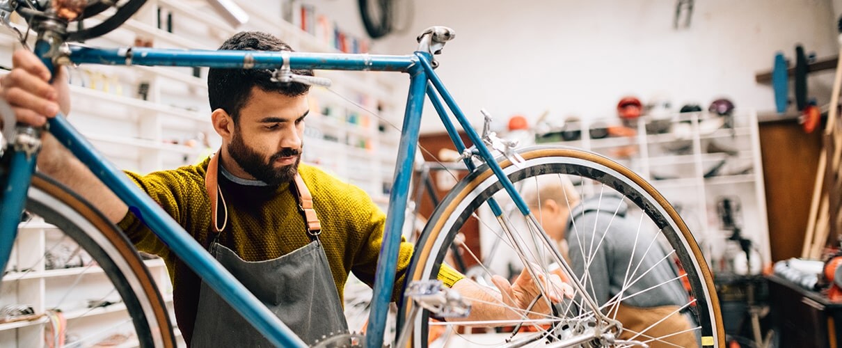 Bike shop owner repairing a vintage bicycle
