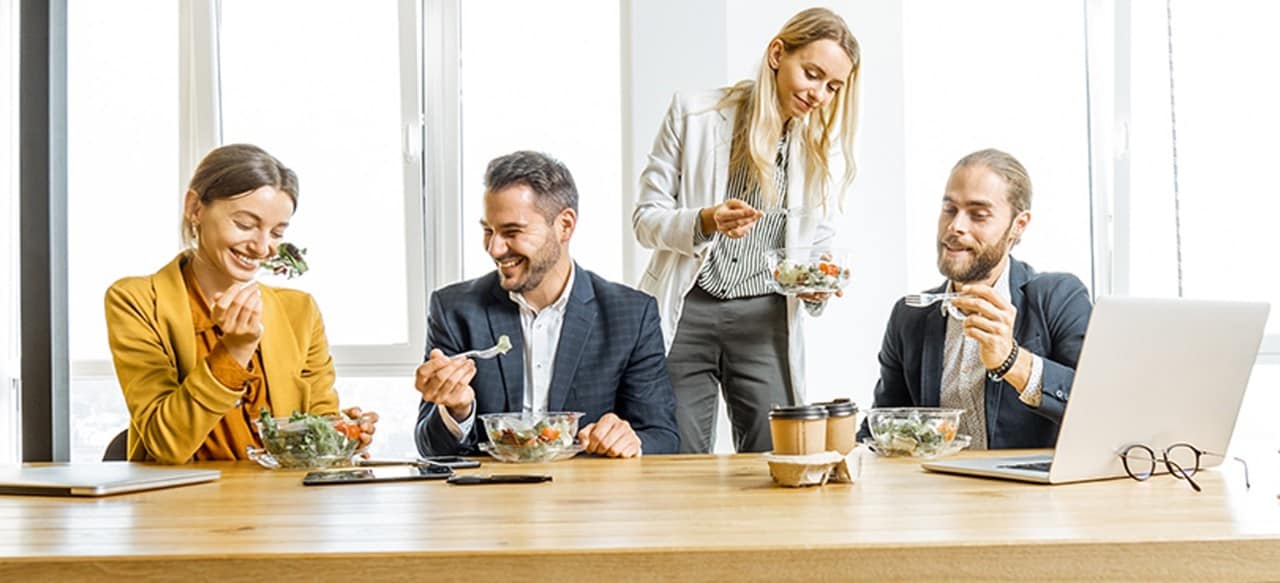 Employees eating boxed lunches at business meeting