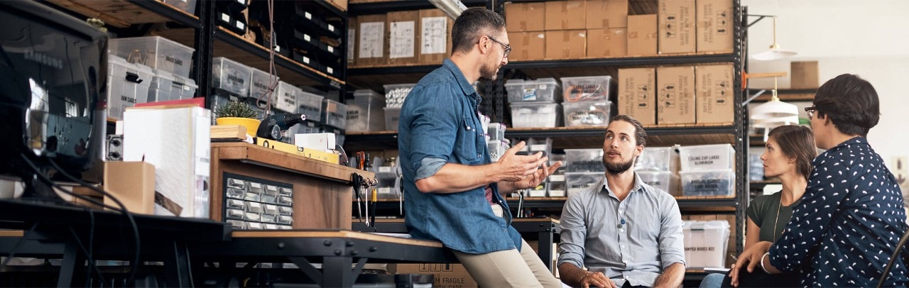 Four colleagues conversing in a warehouse