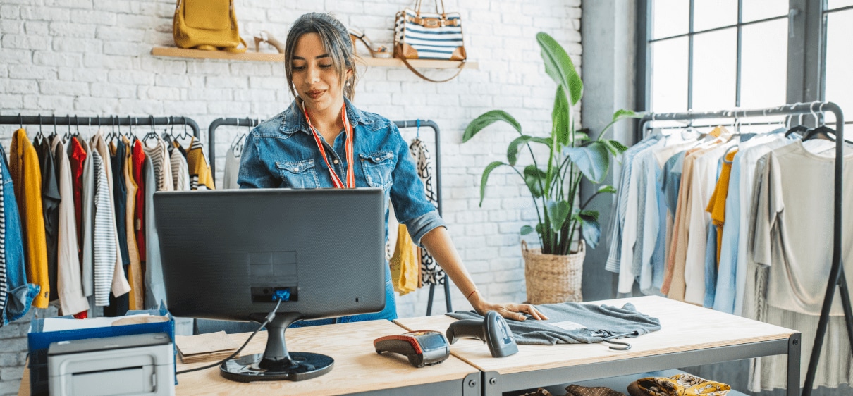 Female clothing store owner using desktop computer