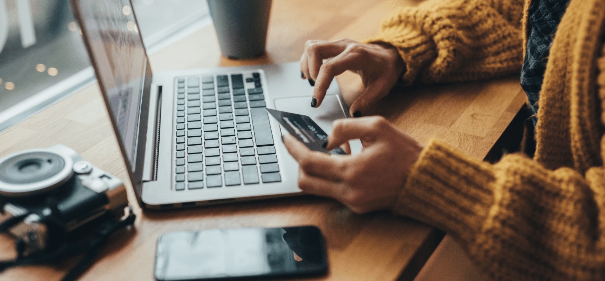 Woman using laptop to make credit card purchase