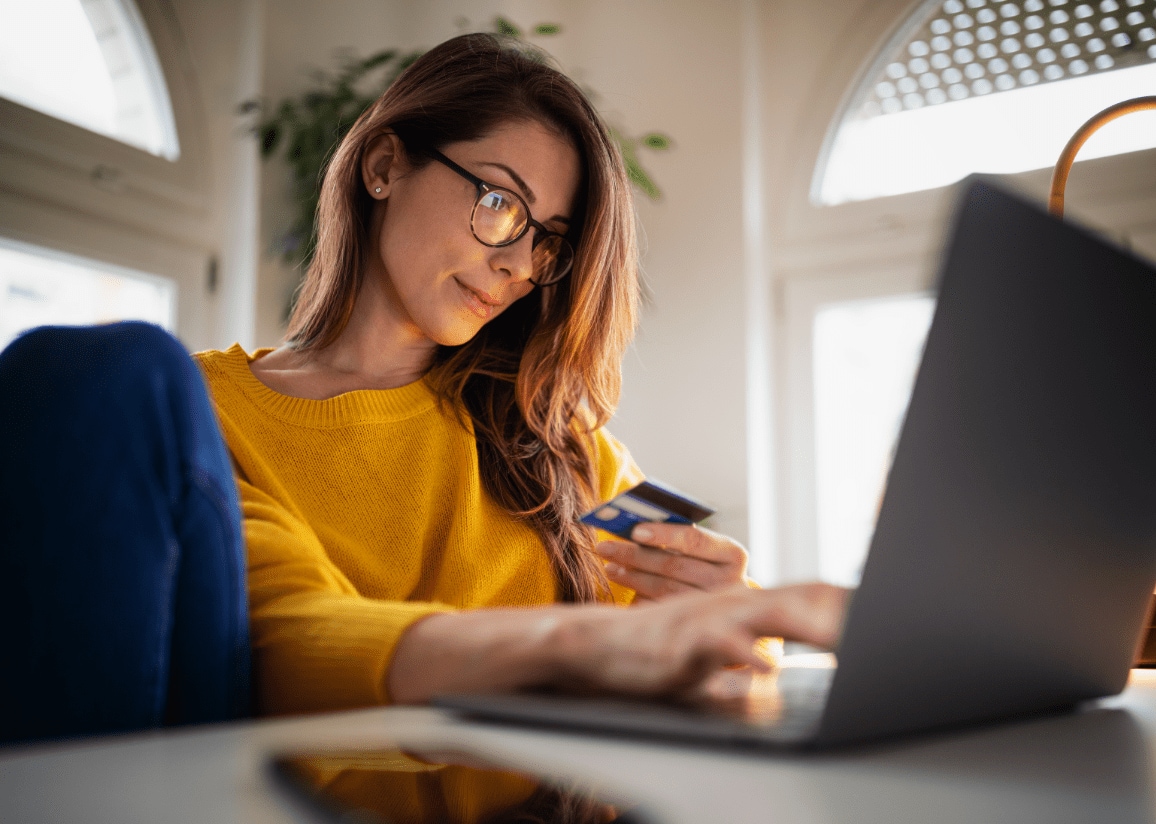 Woman using laptop to make a debit card purchase