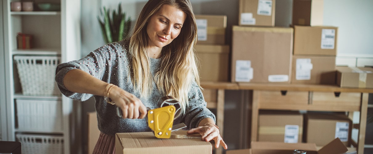 Female business owner preparing box for shipping