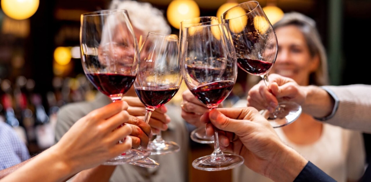 Group of friends toasting with glasses of red wine