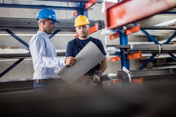 Two construction workers look over a blueprint