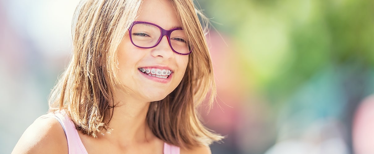 Happy young girl with braces and glasses