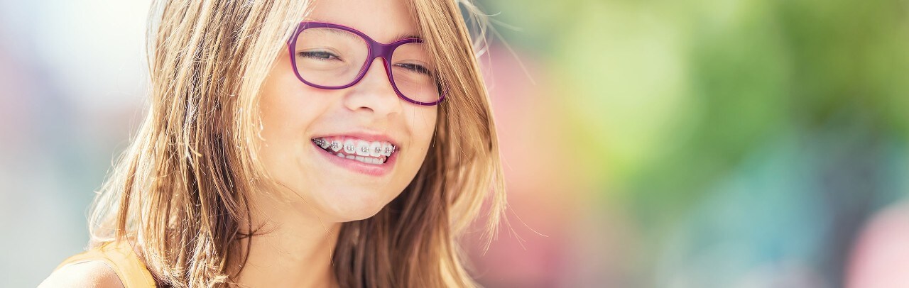 Happy young girl with braces and glasses