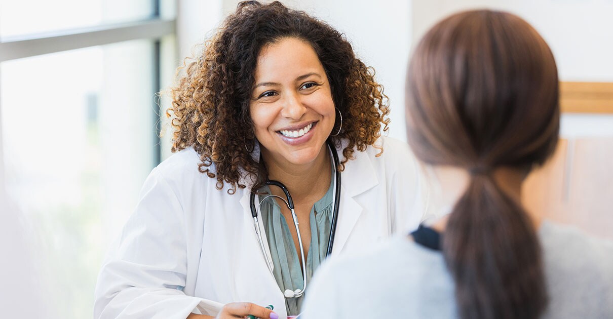Smiling female physician speaking to patient