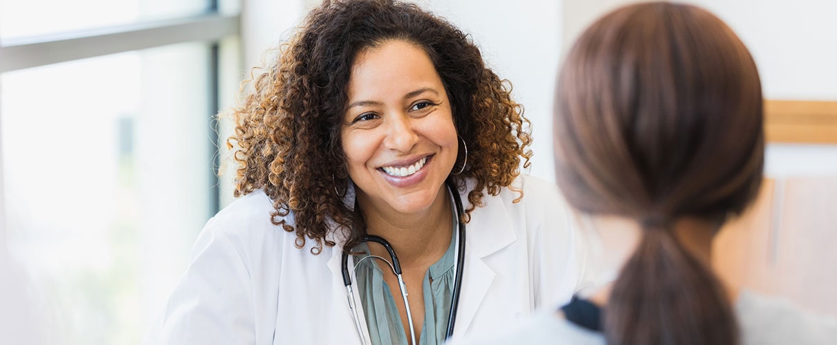 Smiling female physician speaking to patient