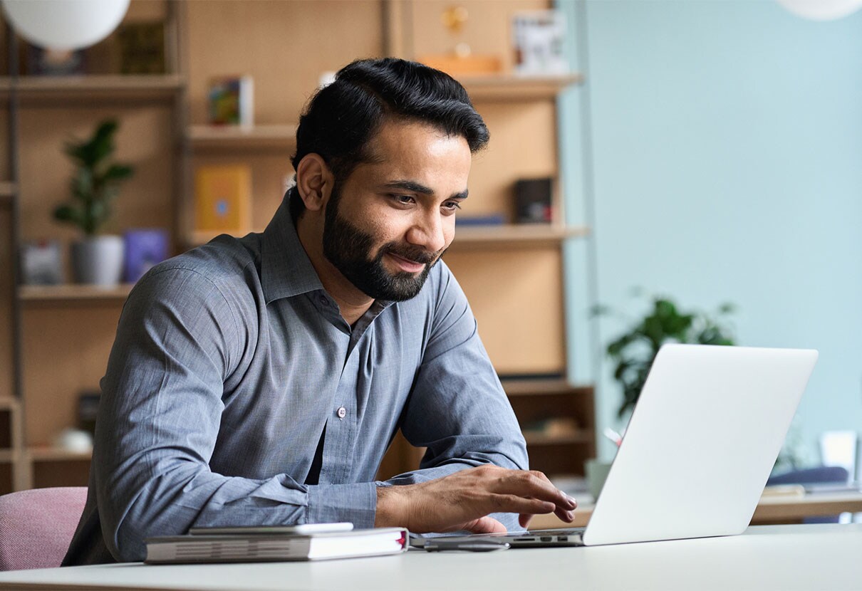 Smiling man looking at laptop