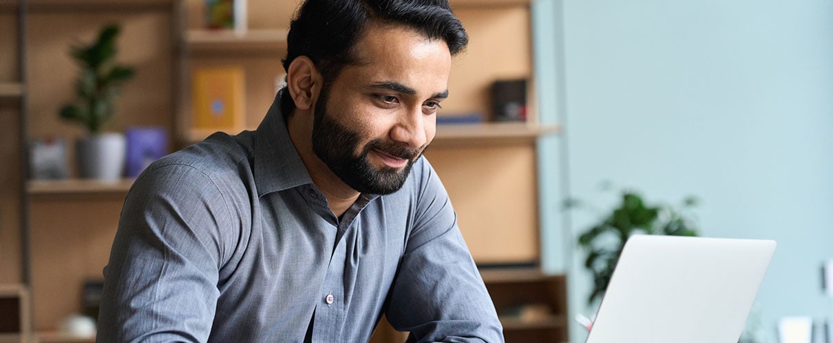 Smiling man looking at laptop