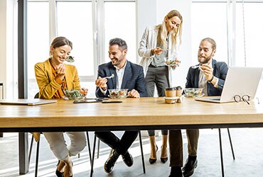 Coworkers eating lunch at conference table