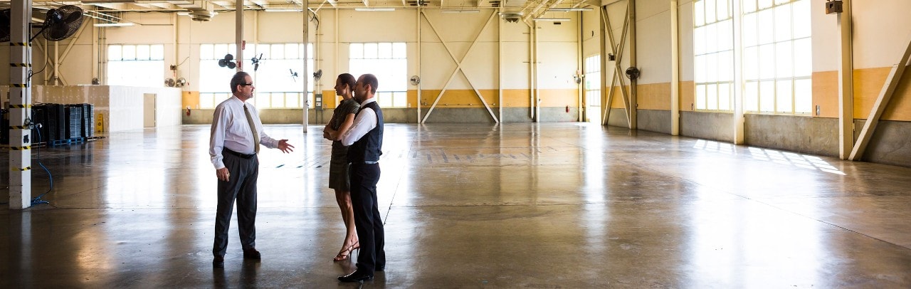 Businessmen an businesswoman meeting in empty warehouse.