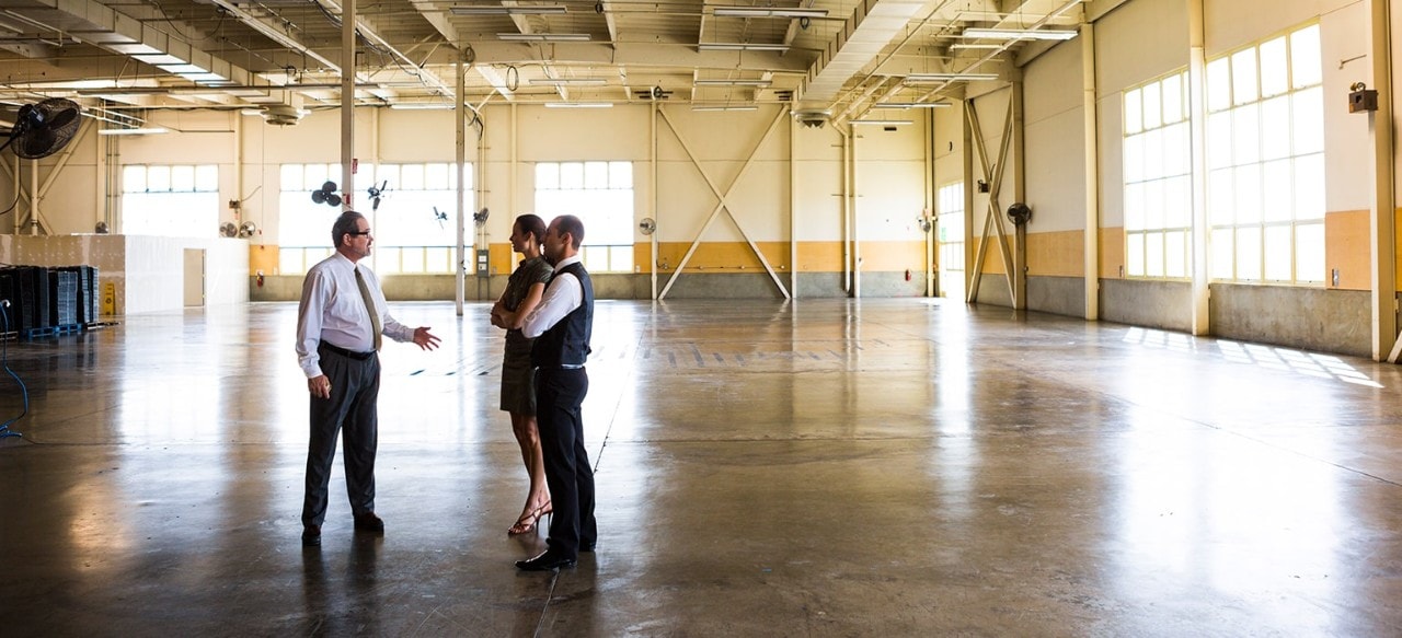 Businessmen an businesswoman meeting in empty warehouse.