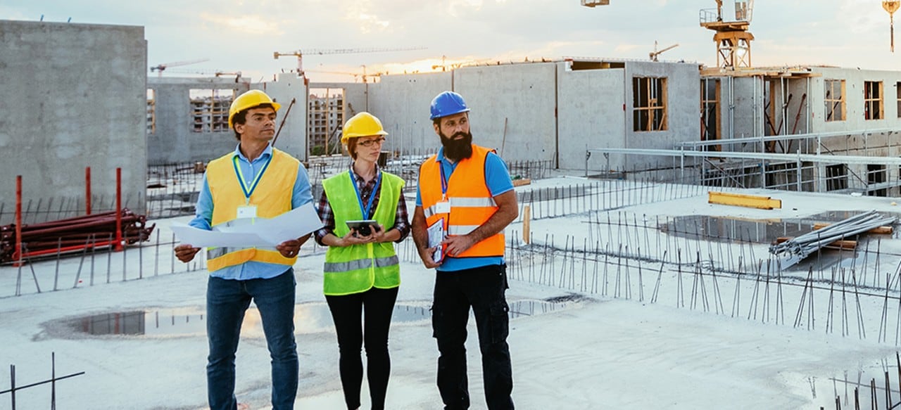 Employees working on construction site, wearing protective equipment