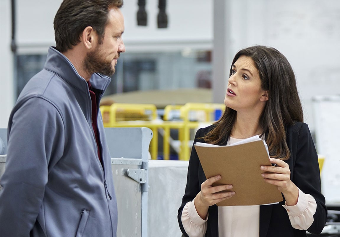 Female banker meeting with business owner in factory