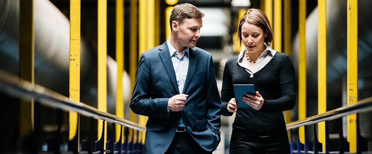 Financial advisor walking through manufacturing plant with client