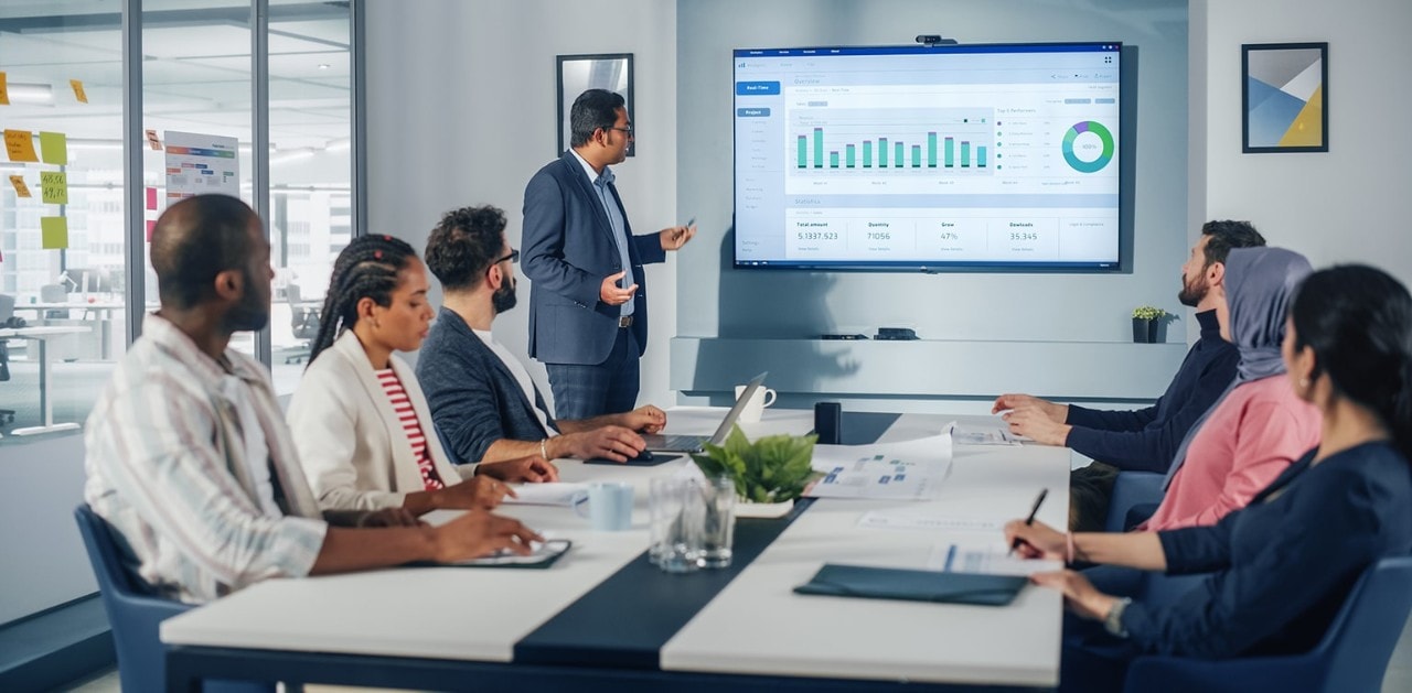 Business team reviewing finances on large screen in conference room