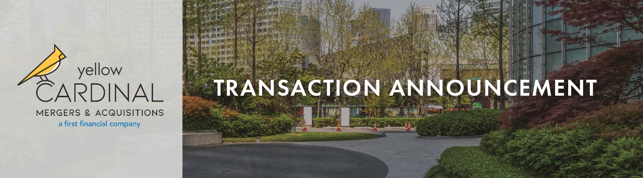 Yellow Cardinal Mergers & Acquisitions logo above a freshly landscaped office property