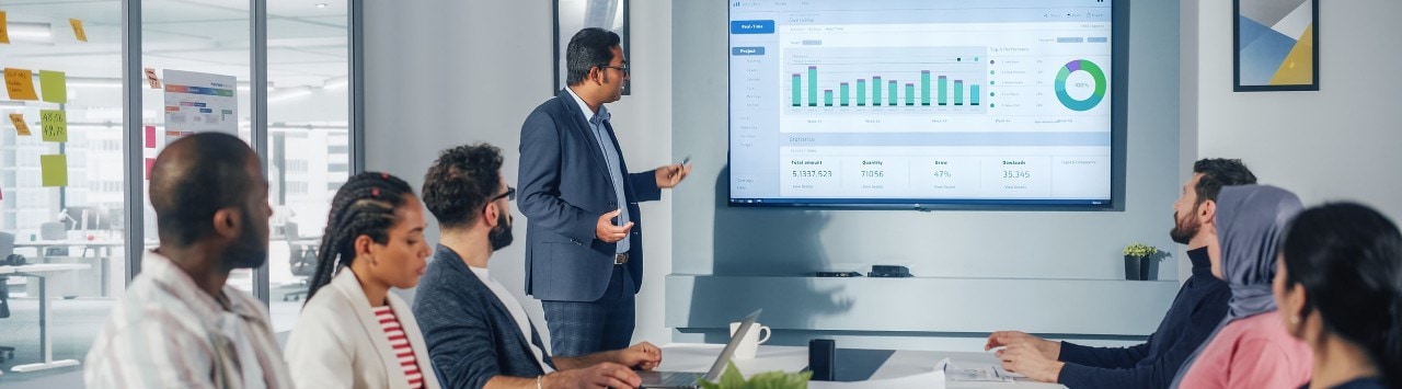 Business team reviewing finances on large screen in conference room