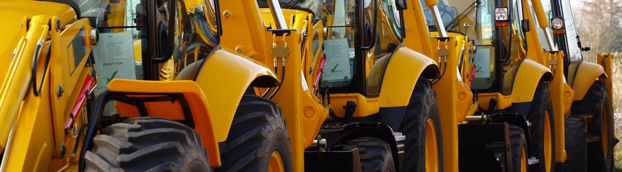 Several backhoe loaders in single-file line