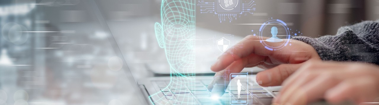 Hands typing on a laptop, with superimposed graphics of facial scans and fingerprints