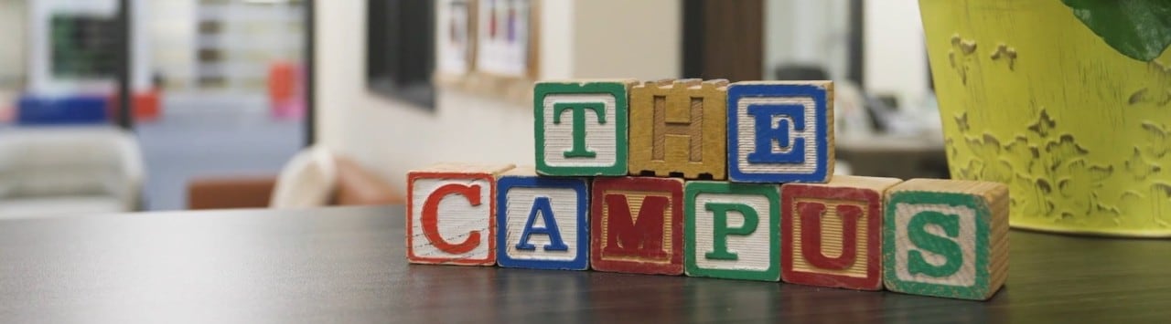 Children’s blocks arranged on a counter to spell “The Campus.”