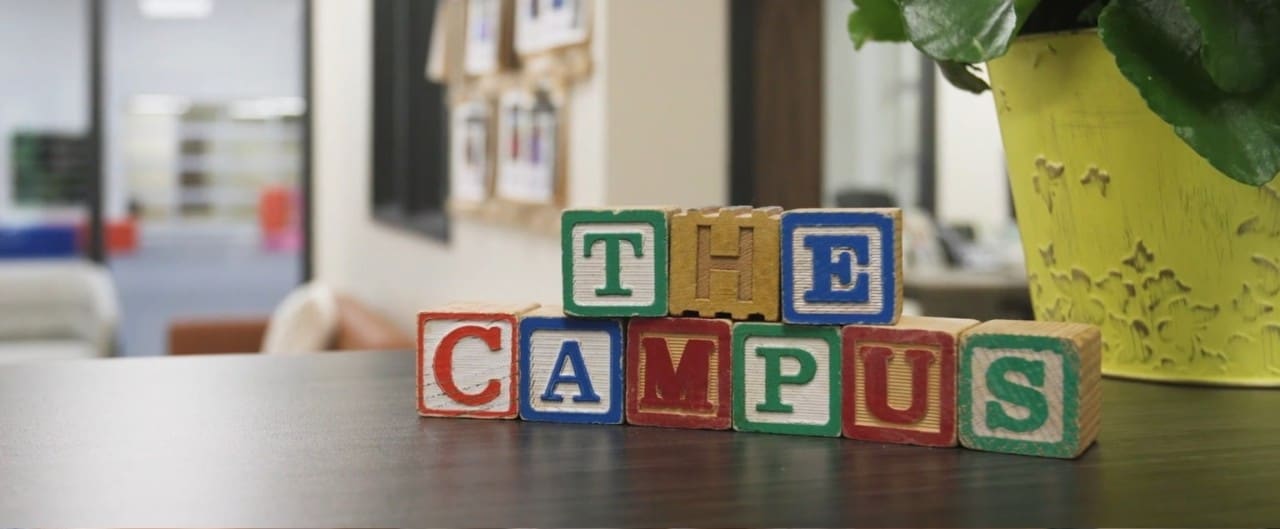 Children’s blocks arranged on a counter to spell “The Campus.”