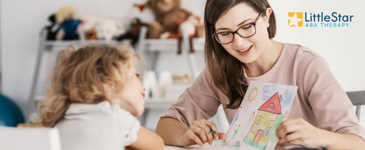 Woman and young girl looking at girl's drawing, with LittleStar ABA Therapy logo in corner