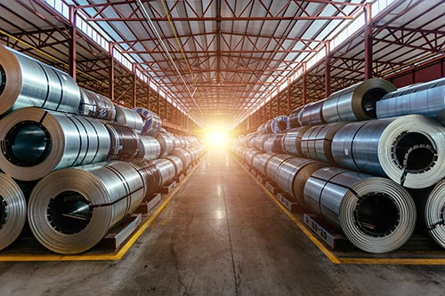 Coils of metal stored in a large warehouse