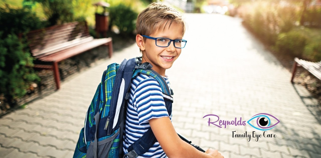 Young boy wearing glasses with superimposed Reynolds Family Eye Care logo