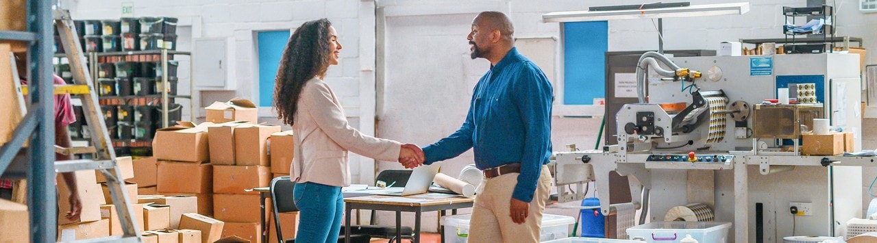 Two business owners shaking hands after business acquisition