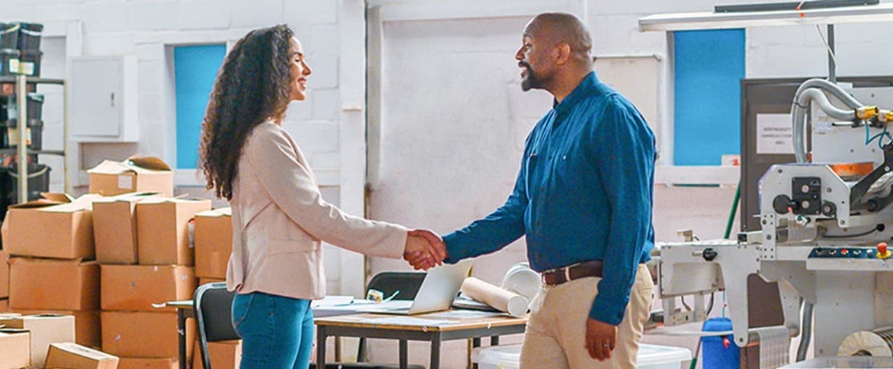 Two business owners shaking hands after business acquisition