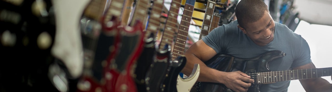 African-American man playing a guitar in a music store