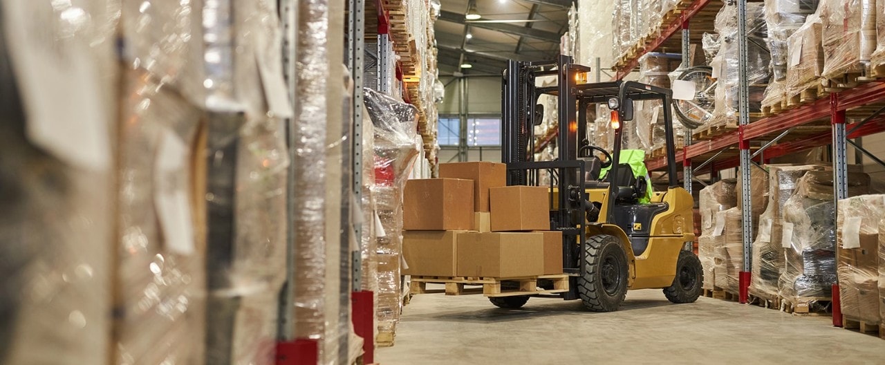 Forklift moving boxes in shipping warehouse