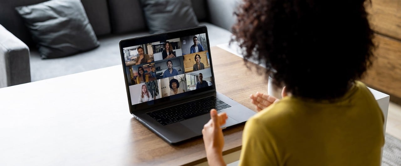 Female small business owner conducting video conference with employees