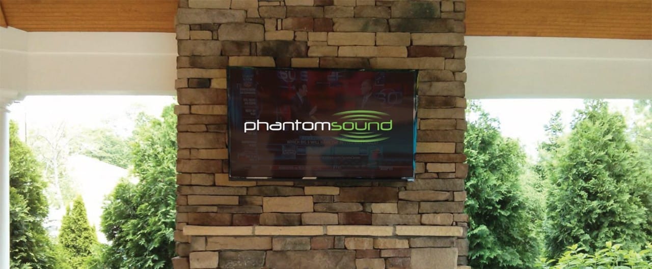 Television hung on a stone mantle displaying Phantom Sound logo