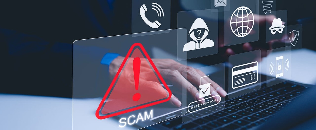 A person typing on a laptop. In the foreground, icons show alerts and potential scams.