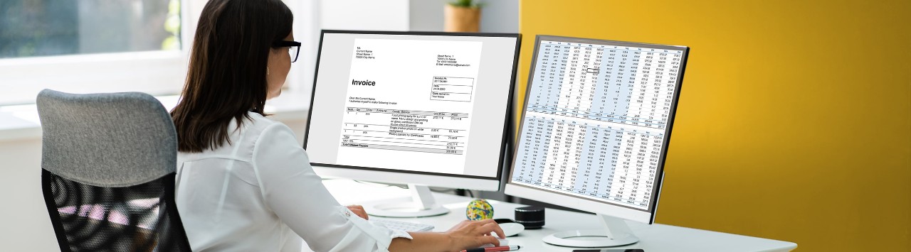 Female business owner reviewing finances on two computer screens