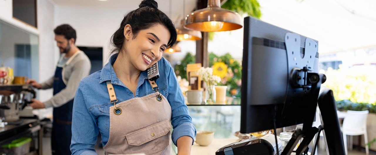 Female coffee shop owner taking order over the phone